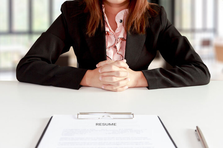 woman at table sitting across from clipboard